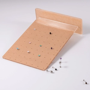 Macro detail of acrylic jewelry display stand with colorful piercing studs in round holes