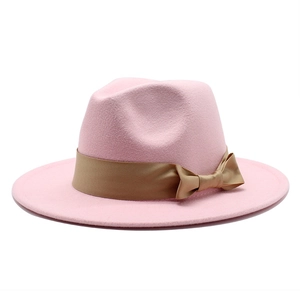 Elegant pink wool felt boater hat with a champagne satin ribbon and bow on white background