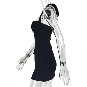 Detail of black halter neck mini dress featuring side pleats and decorative pocket flap