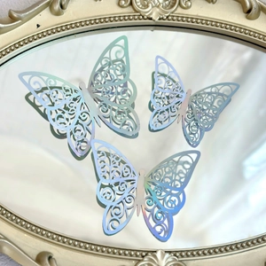 Macro shot of laser hollowed paper butterfly toppers on a gold vintage mirror