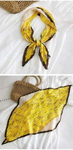 Dettaglio foulard di seta plissettato con motivo floreale in elegante giallo zenzero
