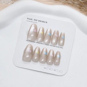 Pearlescent almond press-on nails with colorful hearts on white display tray