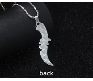 Macro shot of silver metal reaper scythe necklace back with diamond grid texture