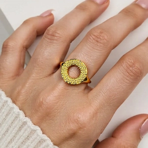 Detailed close-up of a 18K gold plated ring with hammered texture and hollow design