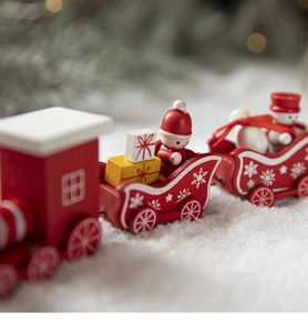 Close-up of a three-section red wooden Christmas train with festive figurines and snowflakes