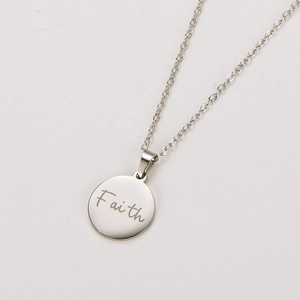 Detailed view of silver stainless steel round pendant with engraved Faith lettering