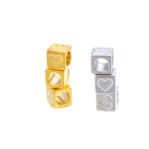 Detailed view of 6mm square stainless steel beads with heart charms in gold and silver