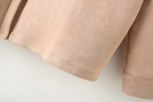 Detailed close-up of premium beige suede fabric texture and professional stitching seams