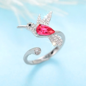 Macro-detail van kolibrie-ring met peervormige rode steen en witte zirkoonstenen