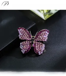 Detailed close-up of a butterfly brooch with purple and pink gradient rhinestones