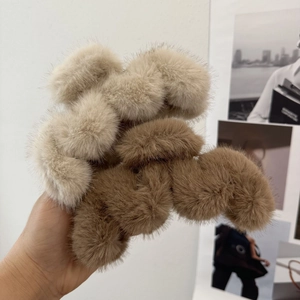 Plush faux fur hair claws in beige and camel colors for women's elegant hair styling