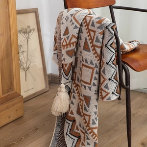Macro detail of Bohemian knit blanket with geometric patterns and soft fringed edges