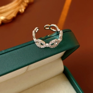 Macro detail of silver plated open ring with pavé cubic zirconia on green velvet box