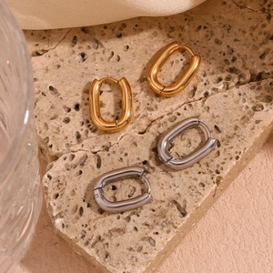 Close-up of minimalist oval hoop earrings in 18K gold and silver stainless steel
