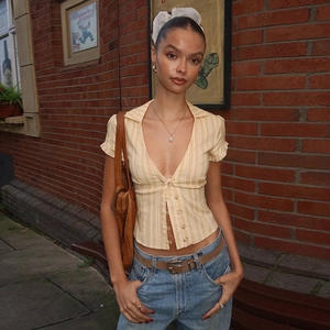 Gros plan d'un haut jaune à rayures avec col polo et boutons de style vintage