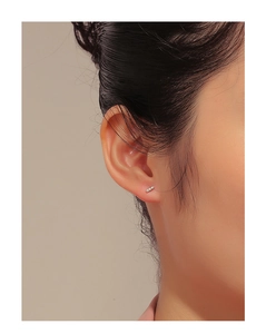 Close-up of minimalist S925 silver bar earrings with inlaid zircons on ear lobe