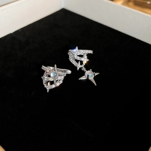 Detail of silver asymmetric star earrings with sparkling zircon and moonstone accents
