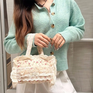 Détail des finitions en dentelle blanche sur un sac fourre-tout en toile florale