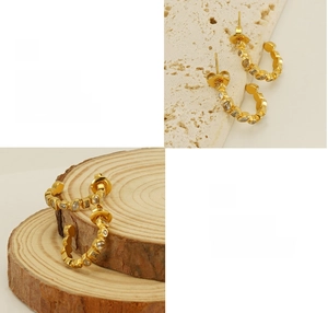Detailed view of polished 18k gold-plated C-shaped earrings with marquise cubic zirconia