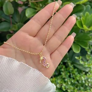 Detail of 18K gold-plated dragon pendant featuring intricate red zircon stone inlay