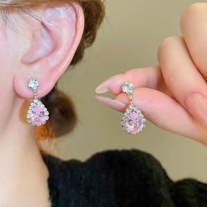 Close-up of pink water drop crystal earrings with sparkling rhinestone halo on silver setting