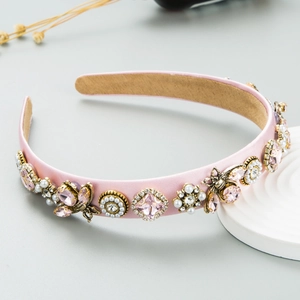 Pink satin headband with vintage gold bees, faux pearls and crystals on a white tray