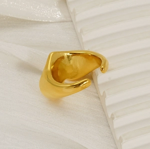 Macro detail of minimalist wide irregular gold plated stainless steel ring with mirror finish