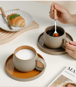 Dettaglio di un set di tazze da caffè in ceramica vintage con cucchiaio in legno e piattino
