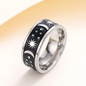 Macro shot of silver ring with black enamel featuring sun, moon and star celestial motifs