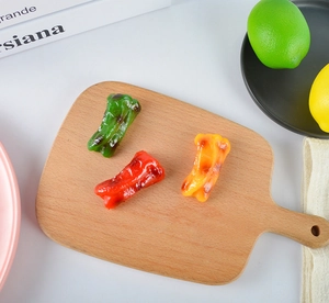 Detailed trio of realistic faux bell peppers in red, green, and orange on a wooden tray