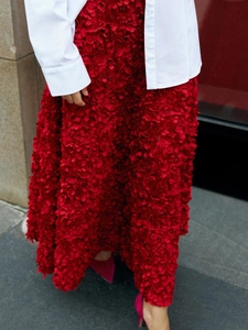 Detail of red 3D petal texture on a long evening skirt with elegant floral applique design