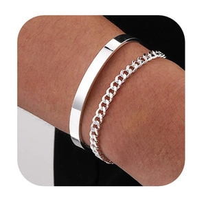 Primo piano di un set di bracciale rigido aperto minimalista argento e catena cubana