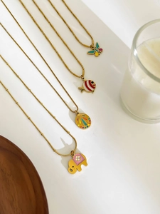 Detailed close-up of gold stainless steel necklaces with colorful enamel animal pendants