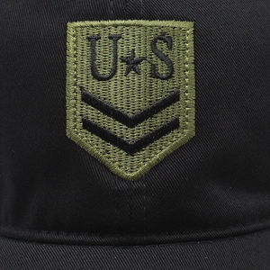 Detailed macro shot of military shield embroidery on a black cotton baseball cap