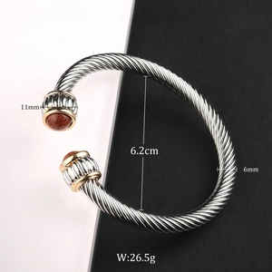 Detail view of steel cable cuff bracelet showing 11mm brown stone ends and 6mm band width