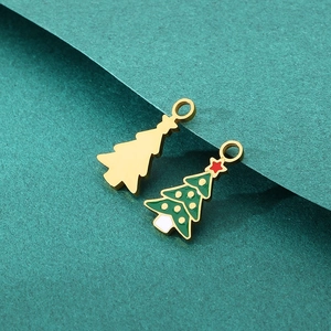 Detailed view of green enamel Christmas tree pendants and gold charms for DIY jewelry