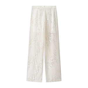 Dettaglio dei pantaloni dritti con paillettes bianco avorio e vita alta elegante