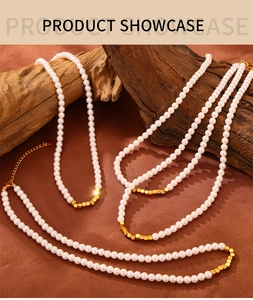 Detailed view of pearl necklace featuring gold cube spacers on rustic wood background