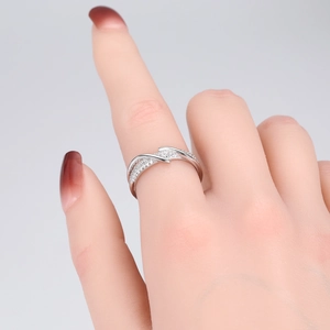 Close-up of S925 silver crossover ring with sparkling pavé stones on a model's finger