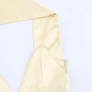 Detailed close-up of pale yellow satin dress featuring delicate straps and elegant cowl neck