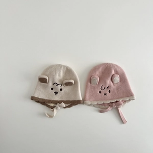Close-up of baby winter knit hats with cute animal embroidery and ear flaps detail