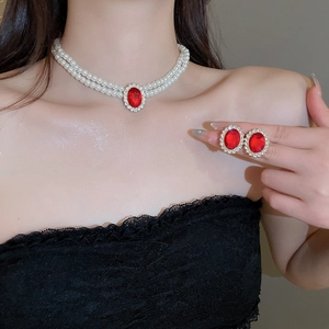 Detail of vintage necklace set featuring red oval stones and double-layer pearls