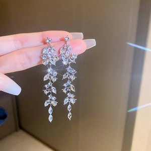Macro shot of silver leaf-shaped tassel earrings with sparkling marquise-cut crystals