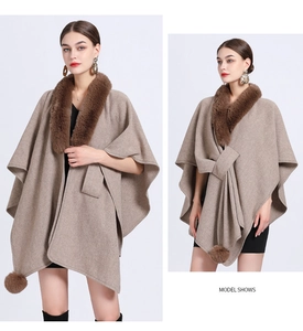 Detail of camel knit cape with plush brown faux fur collar and pompom tassels