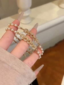 Detailed close-up of zircon copper coin and pearl bracelet in a warm interior setting