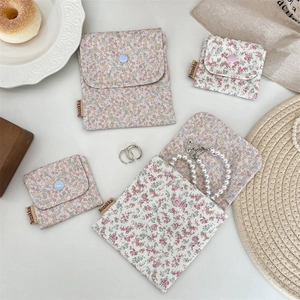 Floral cotton pouch set with snap buttons for coins and cosmetics on a white desk