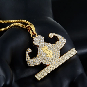 Detailed close-up of hip-hop gold plated pendant featuring a muscular silhouette with rhinestones