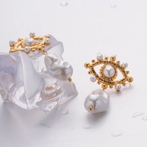 Detail of evil eye flower heart earrings with baroque pearls and gold stainless steel base