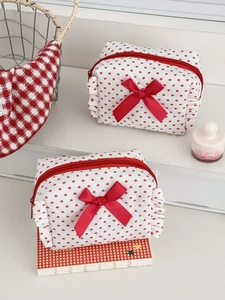 Detailed close-up of quilted heart pouch with red silk bow and decorative ruffled edges