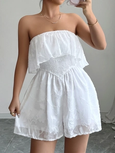 Dettaglio della tutina bianca a fascia con top a balze e tessuto jacquard floreale a trama